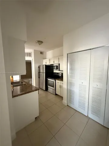 a large kitchen with cabinets and stainless steel appliances