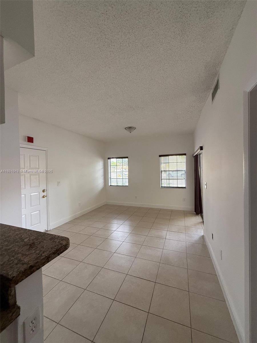 18348 Northwest 68th Avenue, Unit E Hialeah, FL 33015 - Photo 3 of 8 a view of an empty room with window and bathroom