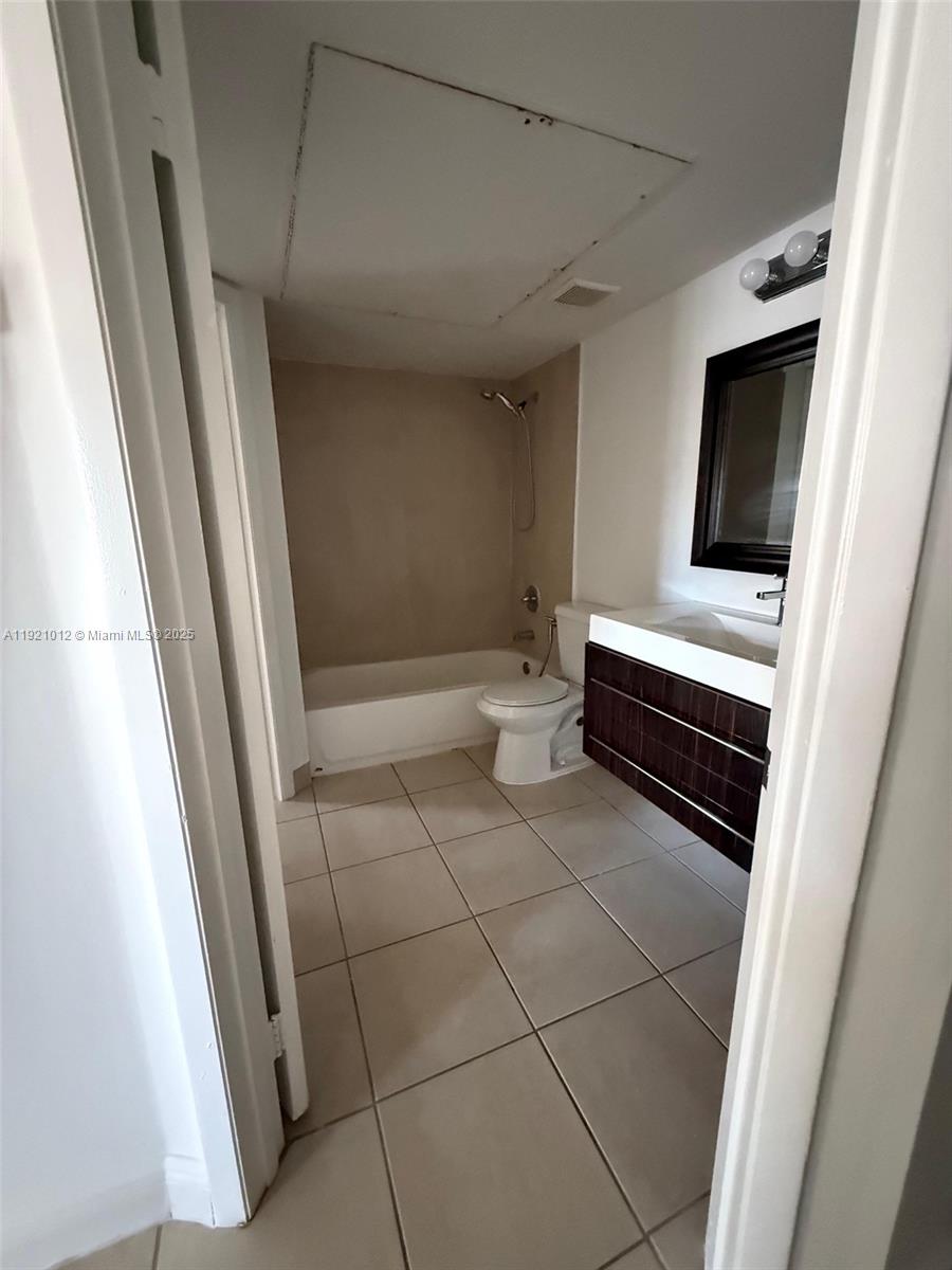 18348 Northwest 68th Avenue, Unit E Hialeah, FL 33015 - Photo 7 of 8 a bathroom with a toilet and a shower