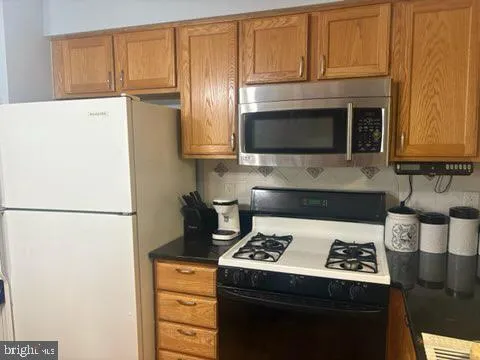 a kitchen with stainless steel appliances a stove a refrigerator and cabinets