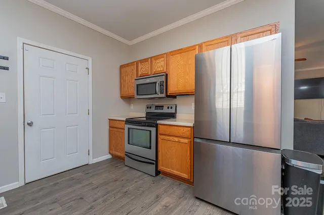 a kitchen with stainless steel appliances a refrigerator sink and microwave