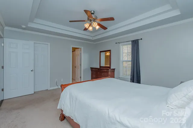 a bedroom with a large bed and a ceiling fan