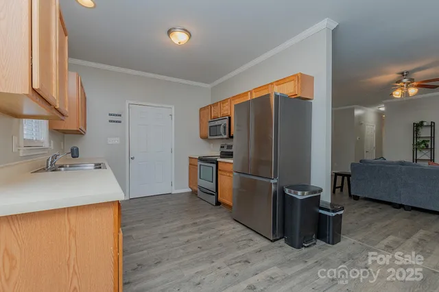 a kitchen with stainless steel appliances granite countertop a refrigerator a sink and a stove