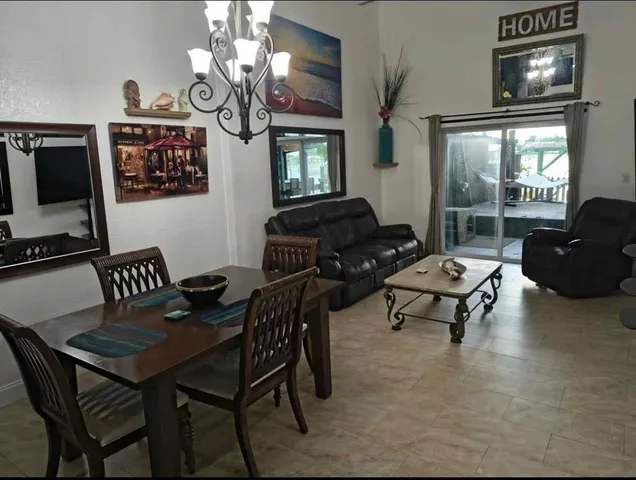a living room with furniture a chandelier and a flat screen tv