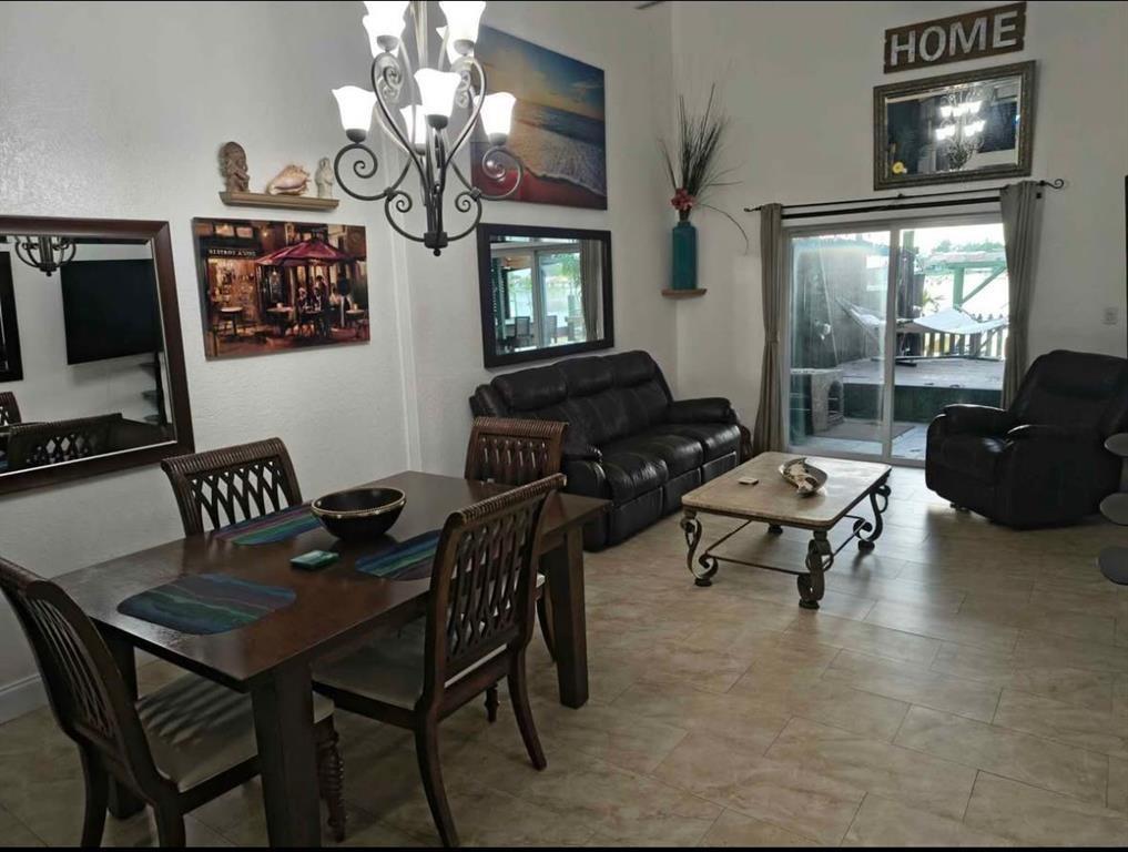 5741 Southwest 24th Avenue, Unit A Fort Lauderdale, FL 33312 - Photo 4 of 14 a living room with furniture a chandelier and a flat screen tv