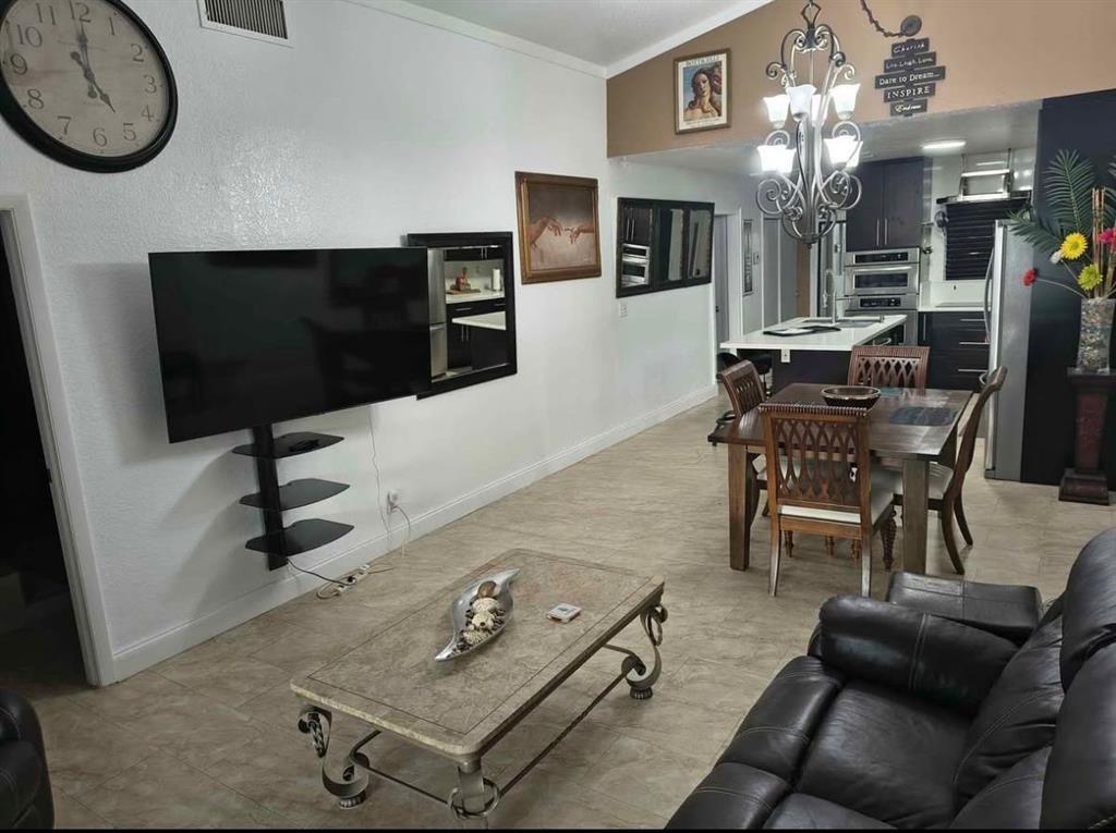 5741 Southwest 24th Avenue, Unit A Fort Lauderdale, FL 33312 - Photo 5 of 14 a living room with furniture a flat screen tv and kitchen view