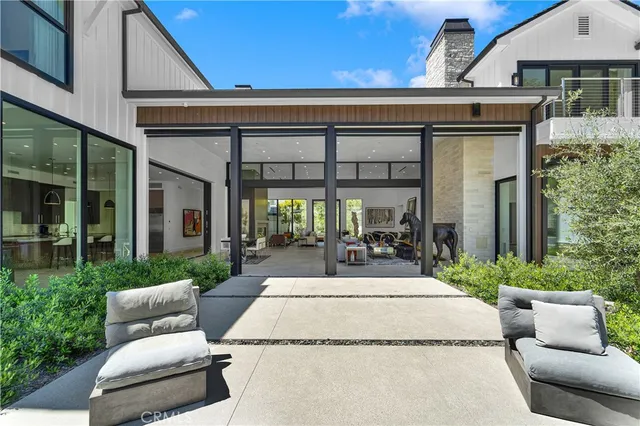 a view of a patio with couches table and chairs and potted plants