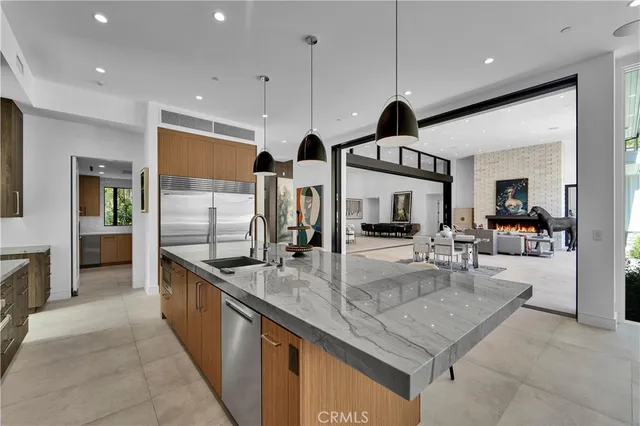 a kitchen with stainless steel appliances granite countertop a sink and a refrigerator