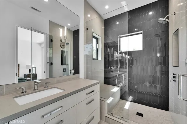 a bathroom with a shower sink and mirror
