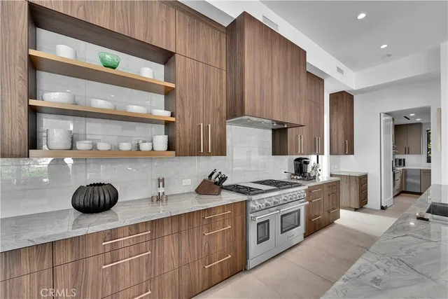 a kitchen with stainless steel appliances granite countertop a stove a sink and a microwave