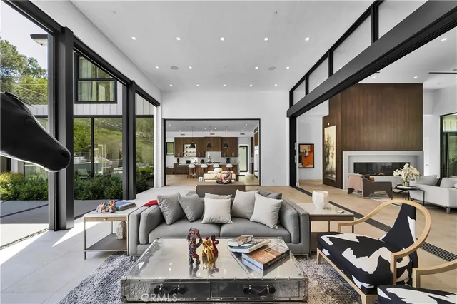 a living room with furniture large windows and wooden floor