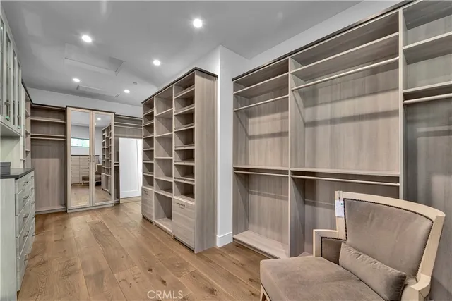 a view of walk in closet with wooden floor
