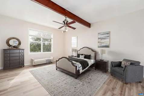 a spacious bedroom with a bed a couch and dresser