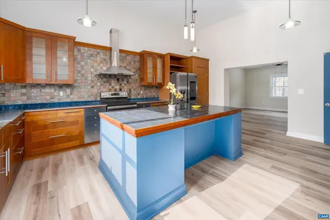 a kitchen with stainless steel appliances kitchen island granite countertop a sink a counter space and cabinets