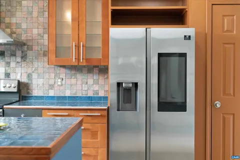 a kitchen with kitchen island a counter top space cabinets and stainless steel appliances