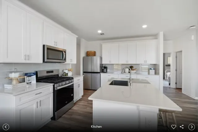 a kitchen with kitchen island white cabinets sink and stainless steel appliances