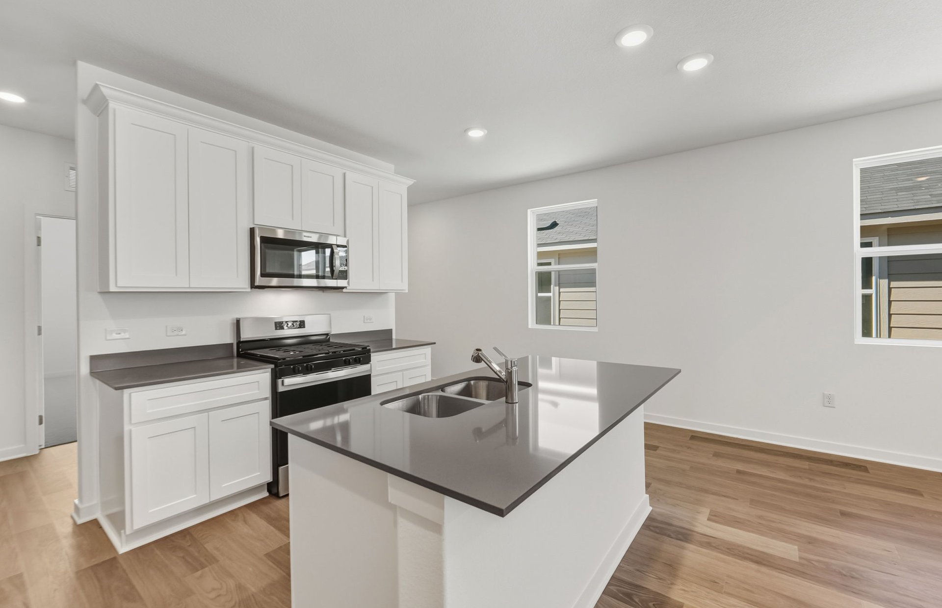 104 Eagle Valley Drive Elgin, TX 78621 - Photo 5 of 18 a kitchen with stainless steel appliances granite countertop a sink a stove and microwave
