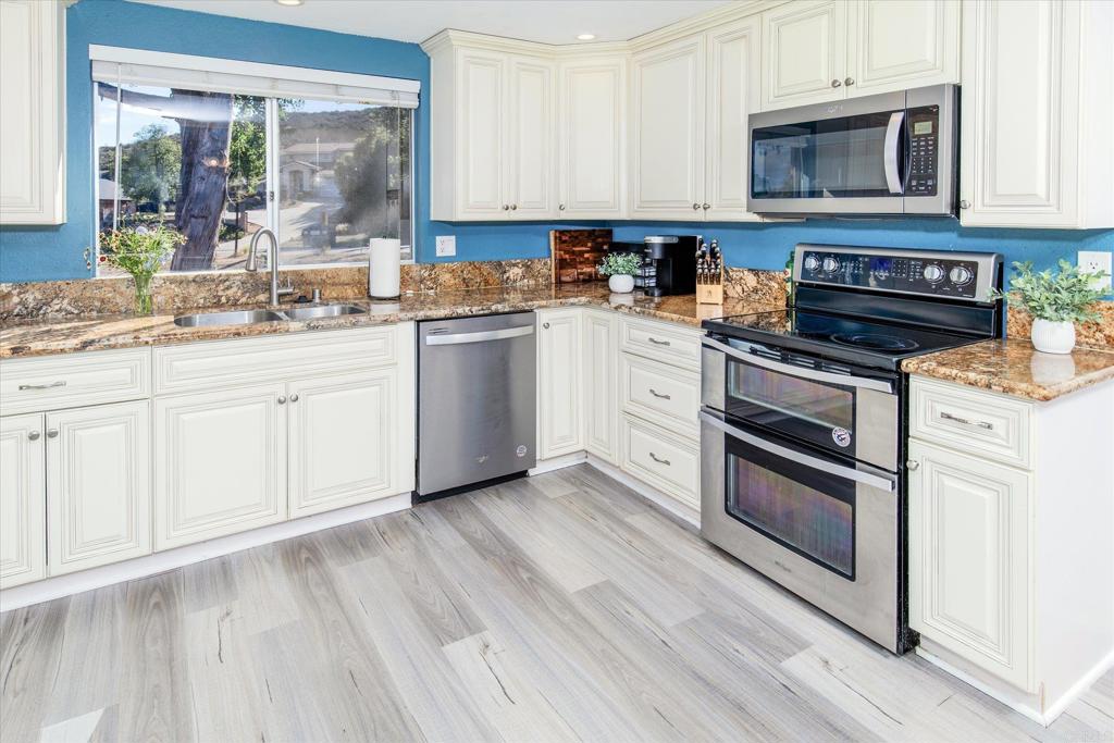 24093 Sargeant Road Ramona, CA 92065 - Photo 11 of 57 a kitchen with stainless steel appliances granite countertop a stove and a white cabinets