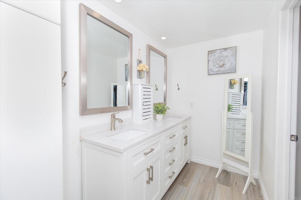 24093 Sargeant Road Ramona, CA 92065 - Photo 19 of 57 a bathroom with a double vanity sink and mirror