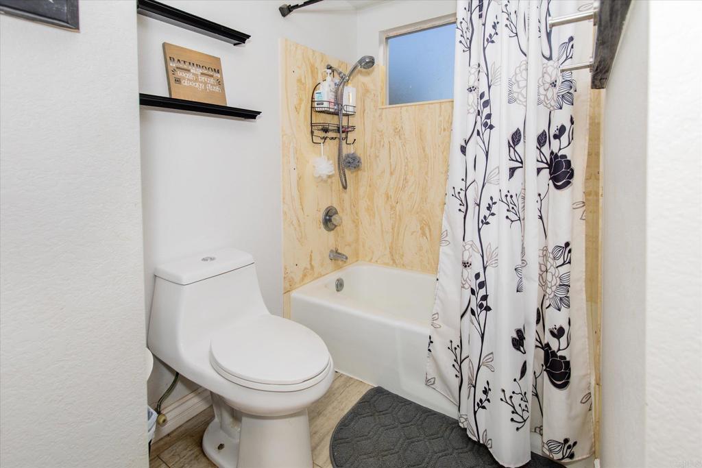 24093 Sargeant Road Ramona, CA 92065 - Photo 27 of 57 a bathroom with a toilet and a shower curtain