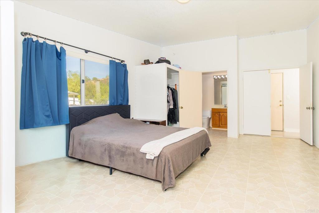 24093 Sargeant Road Ramona, CA 92065 - Photo 29 of 57 a bedroom with a bed and dresser with mirror