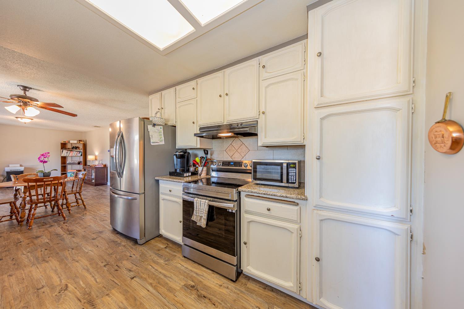 47165 Modoc Road Coarsegold, CA 93614 - Photo 4 of 33 a kitchen with a refrigerator stove and white cabinets