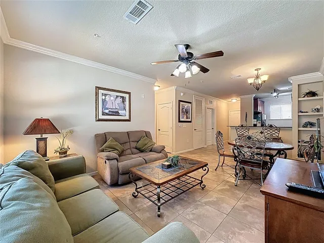 a living room with furniture a chandelier and a window