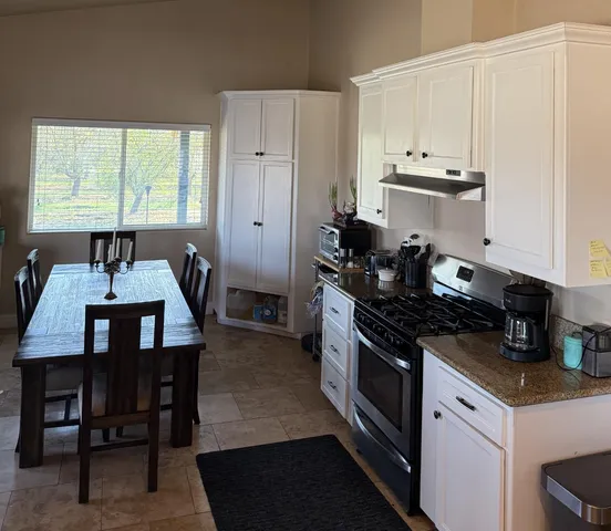 a kitchen with a stove and white cabinets