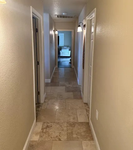 a view of a hallway with wooden shelves
