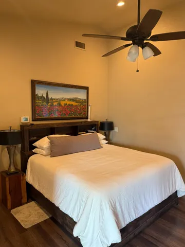 a bedroom with a bed and wooden floor