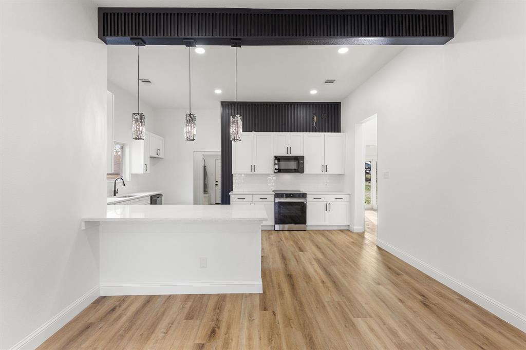1247 Bonham Street Paris, TX 75460 - Photo 5 of 18 a large white kitchen with sink and stainless steel appliances