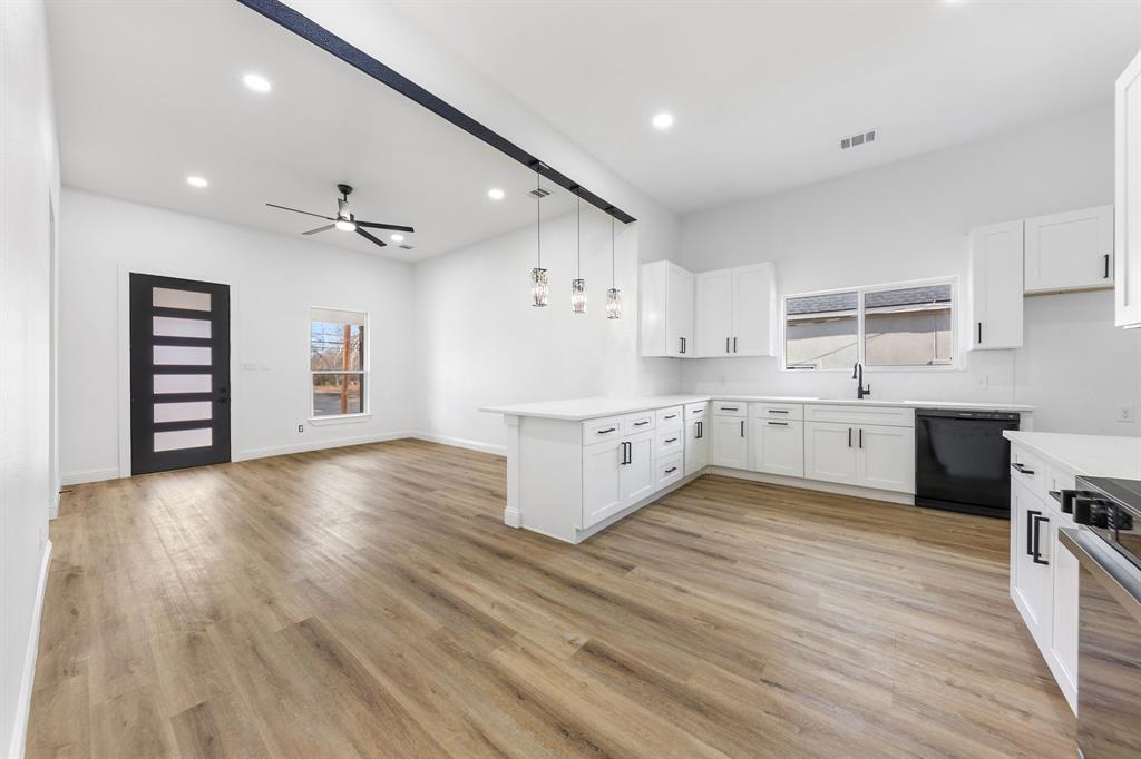 1247 Bonham Street Paris, TX 75460 - Photo 6 of 18 a large room with stainless steel appliances kitchen island a sink wooden floor and cabinets