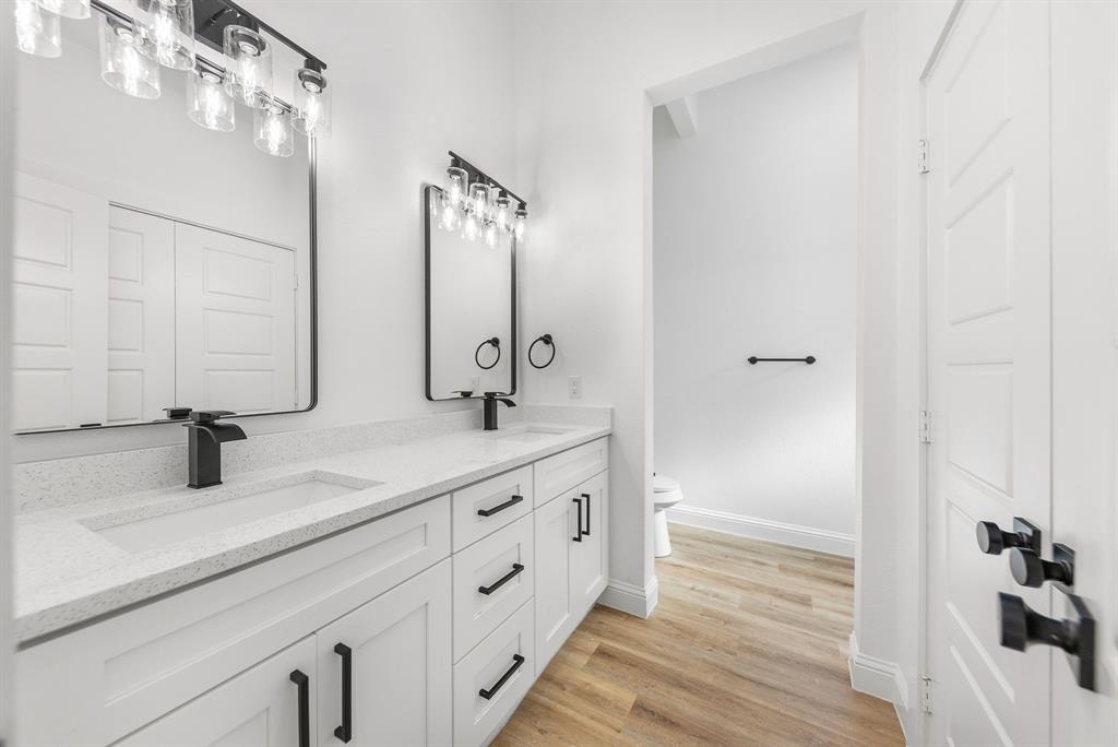 1247 Bonham Street Paris, TX 75460 - Photo 9 of 18 a bathroom with double vanity sink and mirror