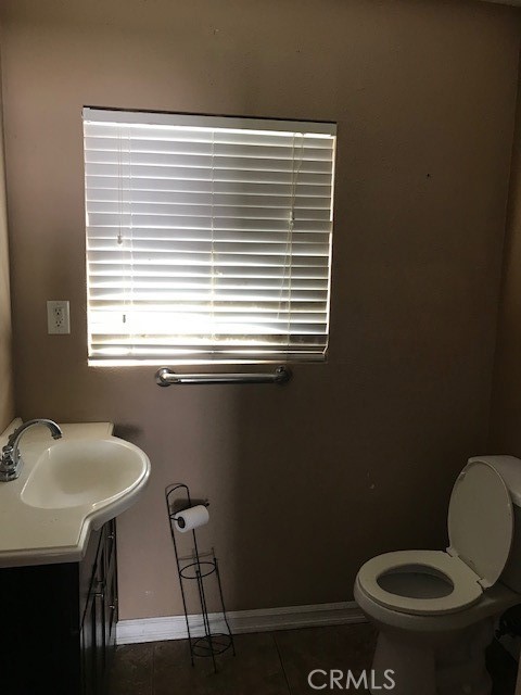 16239 Chicago Avenue Bellflower, CA 90706 - Photo 19 of 30 a bathroom with a toilet a sink and a window