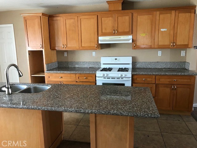 16239 Chicago Avenue Bellflower, CA 90706 - Photo 21 of 30 a kitchen with stainless steel appliances granite countertop a sink stove and cabinets