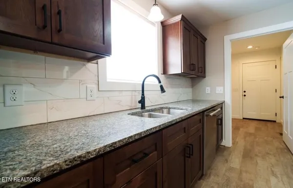 a kitchen with granite countertop a sink and cabinets