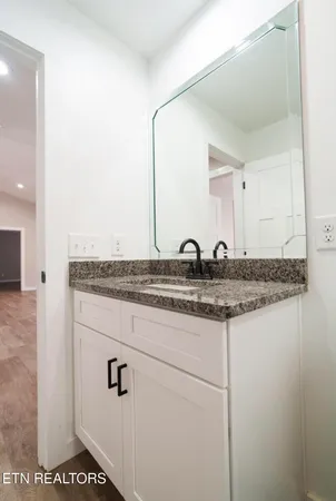 a bathroom with a granite countertop sink and a mirror