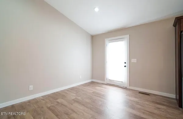 a view of an empty room with wooden floor