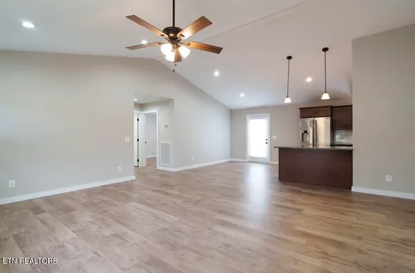an open space with kitchen view and wooden floor
