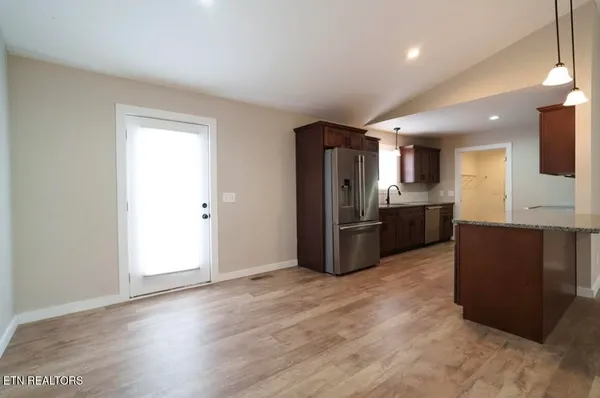 a kitchen with stainless steel appliances kitchen island granite countertop a refrigerator and a sink