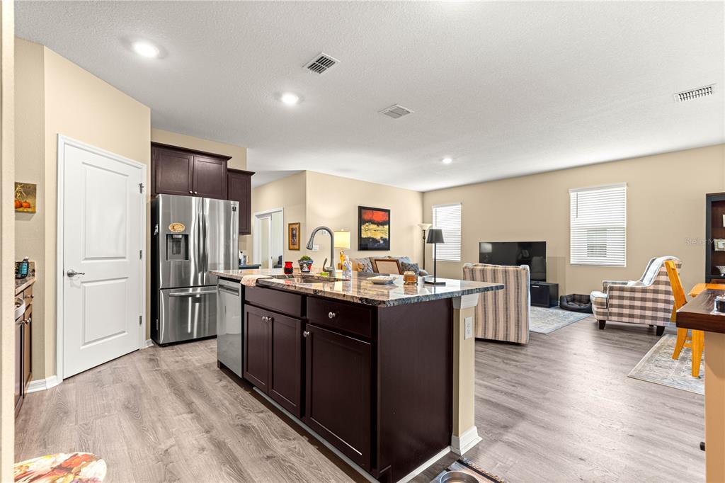 6365 Southwest 88th Loop Ocala, FL 34476 - Photo 12 of 35 a kitchen with stainless steel appliances granite countertop a refrigerator oven a sink dishwasher and wooden cabinets with wooden floor