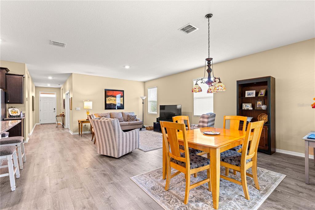 6365 Southwest 88th Loop Ocala, FL 34476 - Photo 15 of 35 a view of a dining room and livingroom with furniture wooden floor a chandelier