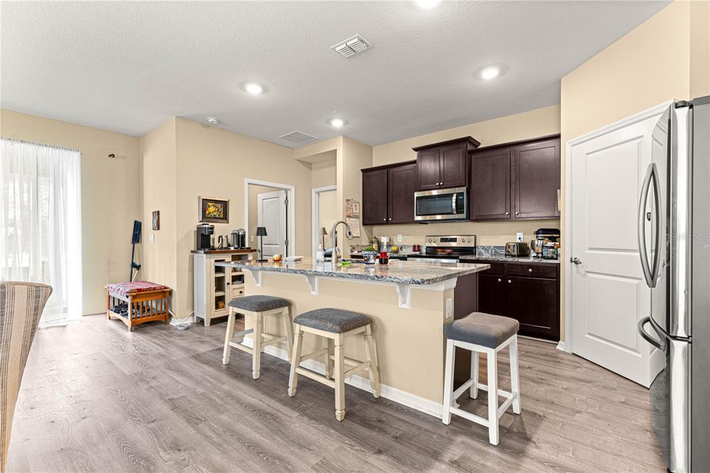 6365 Southwest 88th Loop Ocala, FL 34476 - Photo 10 of 35 a kitchen with a refrigerator a stove a sink and a chairs