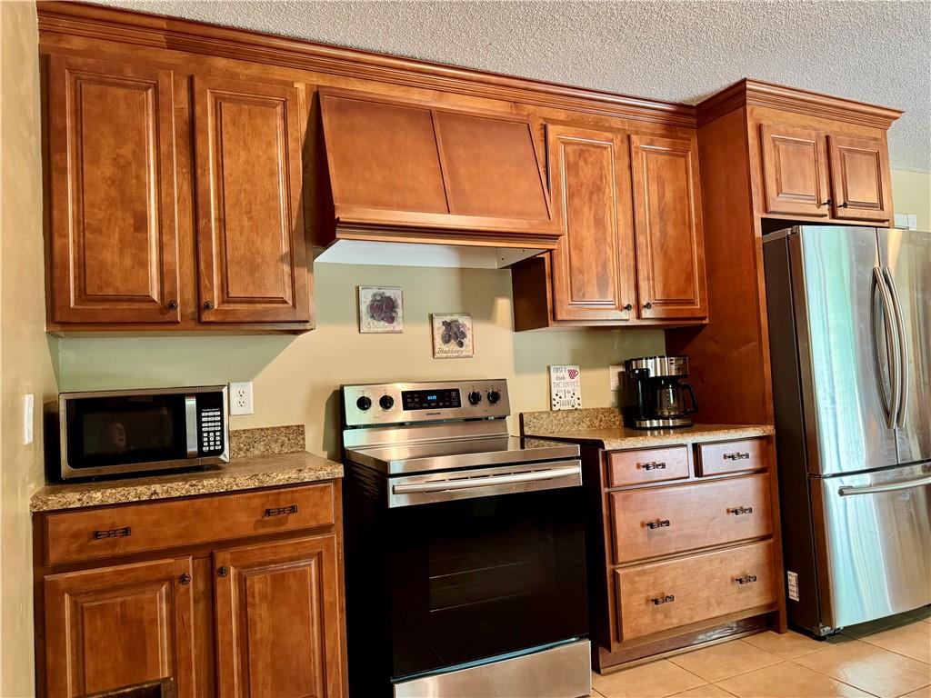 94 Big Jim Road Cleveland, GA 30528 - Photo 15 of 25 a kitchen with granite countertop wooden cabinets and a stove top oven