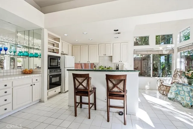 a kitchen with a sink a counter top space and living room view