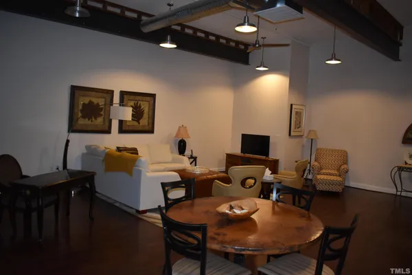 a living room with furniture a lamp and a dining table