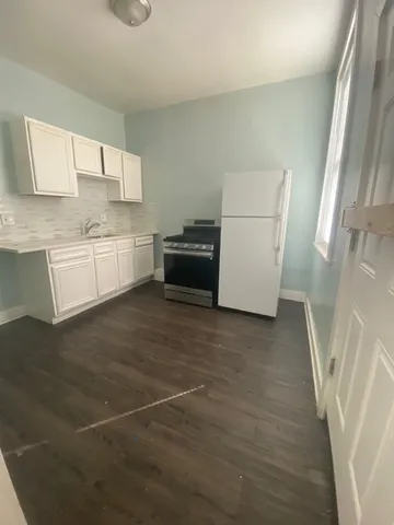 a kitchen with granite countertop white cabinets and white appliances