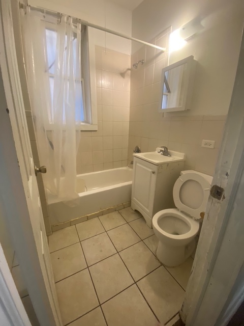 3907 West Monroe Street Chicago, IL 60624 - Photo 10 of 14 a bathroom with a granite countertop sink toilet and shower