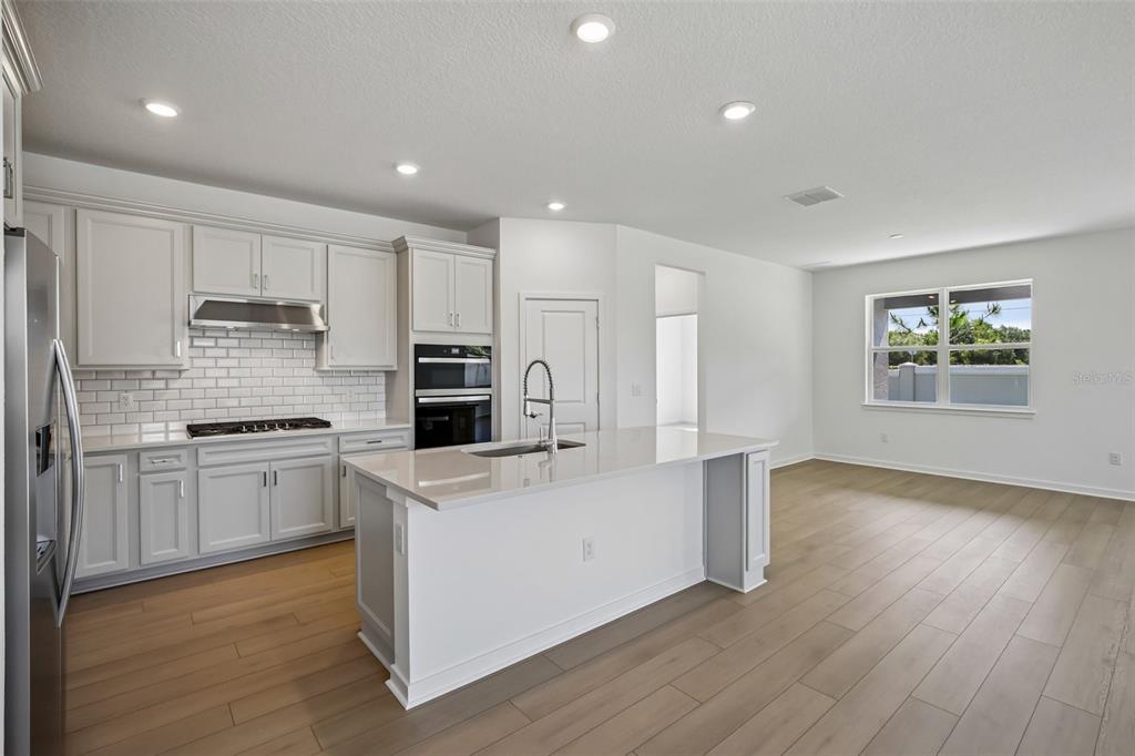 9932 Redwood Rdg Avenue Riverview, FL 33578 - Photo 8 of 38 a kitchen with a stove a sink and a refrigerator