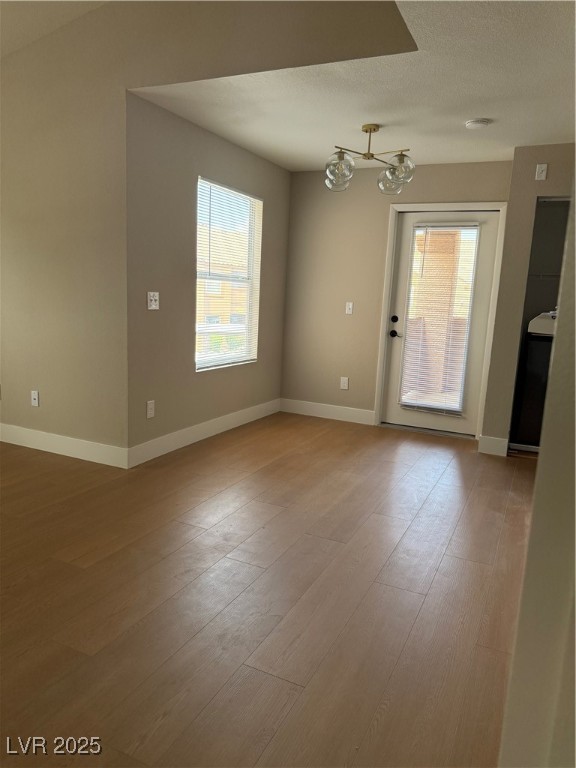 1150 North Buffalo Drive, Unit 2025 Las Vegas, NV 89128 - Photo 1 of 20 Spare room featuring a chandelier and light wood-style flooring